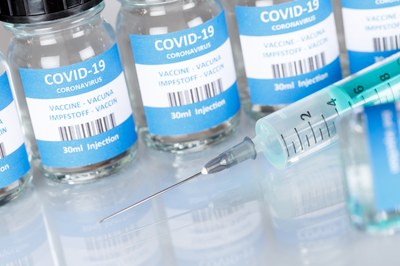 #pracegover foto mostra frascos de vacina contra a covid-19, na cor azul, com seringa ao lado
