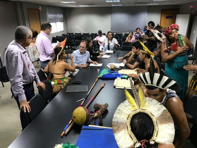 Fotografia de uma mesa com vários indígenas e membros do MPF discutindo os termos do acordo.