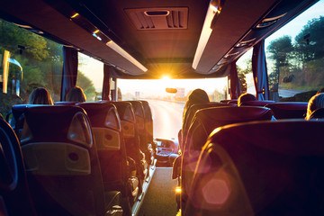 #PraCegoVer Imagem mostra passageiros sentados dentro de um ônibus. Eles são vistos por trás; então não dá pra ver seus rostos