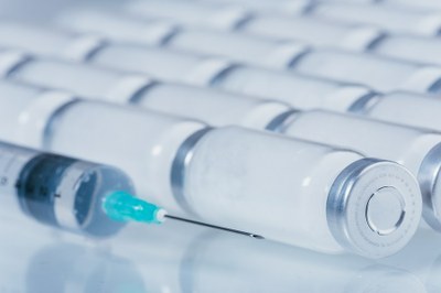 #pracegover Imagem contendo ampolas de vacina e uma seringa com imunizante dentro