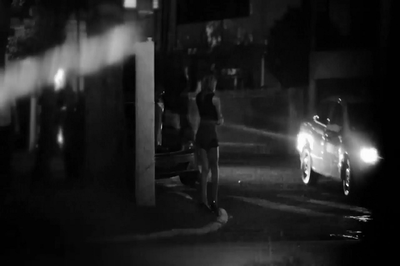 #pracegover: foto de uma mulher na rua de frente para um carro. A foto é de divulgação do IP.