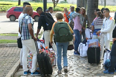 Foto mostra refugiados carregando malas e mochilas