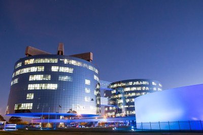 Foto mostra os prédios da PGR ao entardecer com iluminação azul