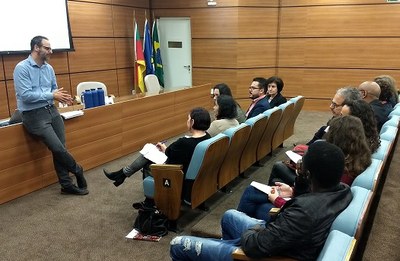 Procurador Fabiano de Moraes em frente aos participantes da reunião sentados no auditório