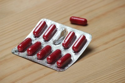 Foto ilustrativa de uma cartela com comprimidos vermelhos