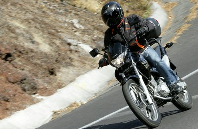 Motociclista em moto em movimento numa curva na estrada