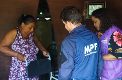Técnico do MPF e técnica da Semudh entregam cadeira para mãe da jovem 