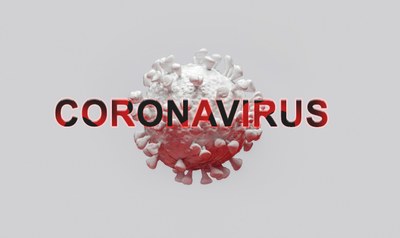Em um fundo branco no centro da imagem se encontra a imagem de uma célula do novo coronavírus.Em sobreposição à célula se encontra na cor vermelha a palavra Coronavírus