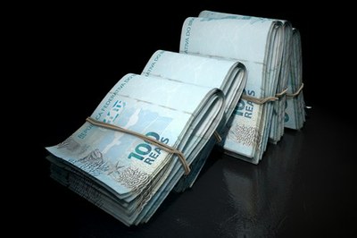 Foto mostra cinco maços de notas de 100 reais