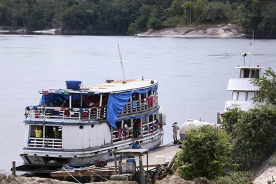 #pracegover foto mostra barco de médio porte ancorado à margem de rio da região amazônica