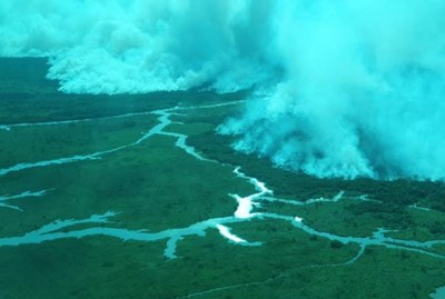 Foto aérea da Reserva Biológica do Lago Piratuba, com floresta em chamas e muita fumaça