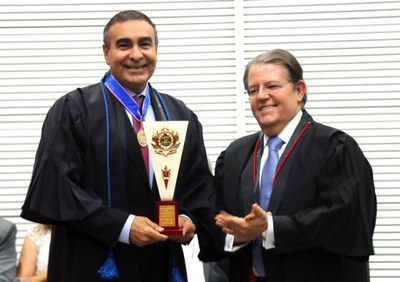 O procurador Cláudio Gusmão recebe homenagem das mãos do desembargador Jatahy Júnior.