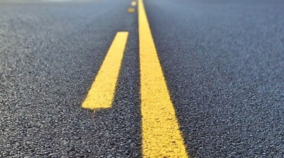 Foto de uma pista asfaltada com duas faixas amarelas