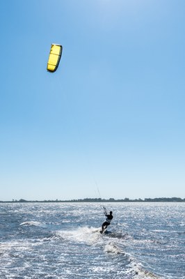 #pracegover Fotografia de um praticante de kitesurf no mar.