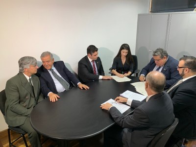 Foto mostra a procuradora da República Gabriela Azevedo assinando o TAC,; à sua esquerda, o procurador Lucas Gualtieri; à sua direita, o presidente da INB; e ao redor da mesa, advogados da empresa 