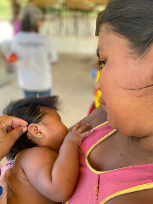 Foto de uma jovem indígena Maxakali amamentando seu bebê
