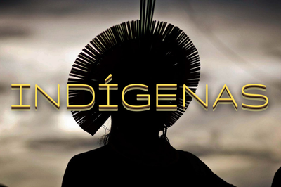 Foto contraluz de um indígena usando um cocar. Em amarelo, no centro da imagem, está escrito Indígenas 