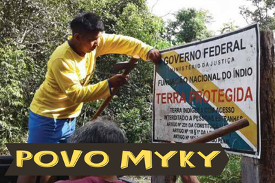 Imagem de indígenas da etnia Myky fazendo a manutenção da fixação da placa que indica que a área é protegida por ser terra indígena. No canto baixo esquerdo está escrito POVO MYKY.