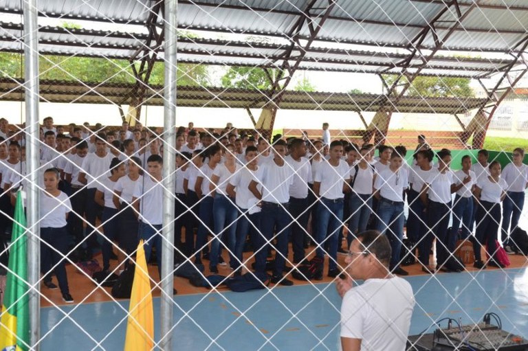 Foto mostra alunos perfilados em uma quadra de esportes