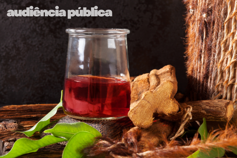 Imagem de um copo com o chá da ayahuasca e ervas e cipós usados no feitio.