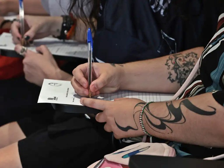 Foto mostra uma pessoa trans preenchendo um formulário