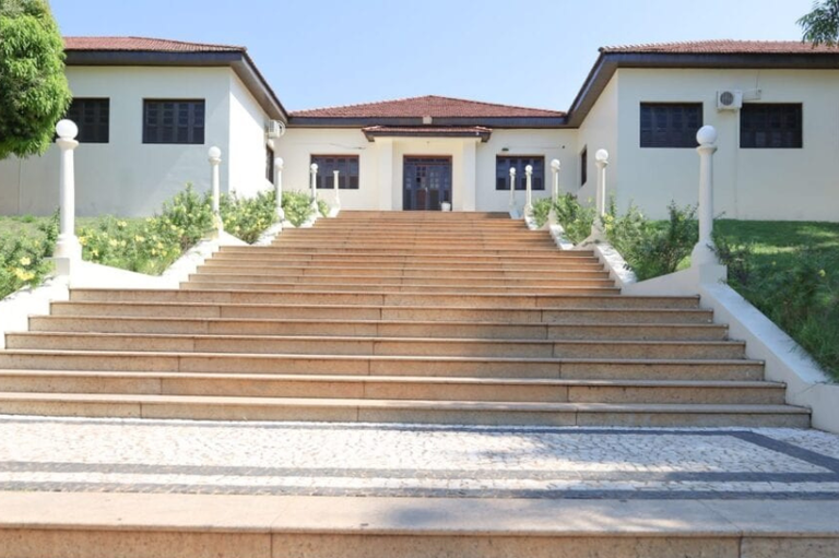 Foto da fachada da Maternidade Bárbara Heliodora, em que se vê a escadaria e, no alto, a entrada da unidade, com gramado e árvore na lateral da escadaria