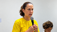 Mulher a discursar com microfone.png