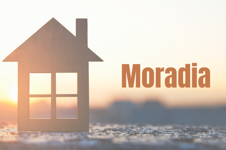 Imagem com fundo desfocado em tons claros, sugerindo um pôr do sol. À esquerda, há a silhueta de uma casa estilizada em madeira clara, com quatro janelas quadradas. À direita, em letras grandes e marrons, está escrito: “Moradia”.