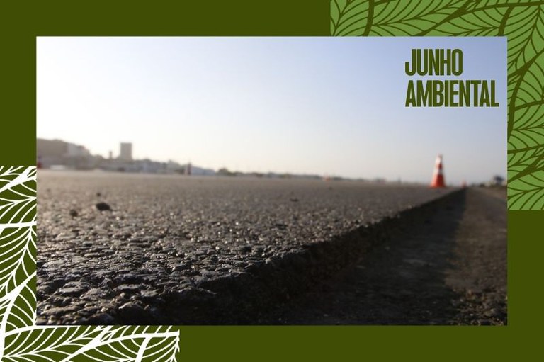 Foto mostra em detalhe o asfalto de uma estrada com um cone de sinalização à frente