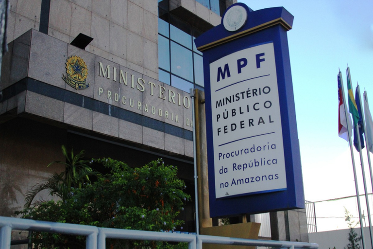 #PraTodosVeresm: Imagem mostra a Fachada do prédio sede do MPF no Amazonas. Na frente há um totem em que se lê "MPF/Ministério Público Federal/Procuradoria da República no Amazonas". Ao fundo um mastro com as bandeiras do Amazonas e Brasil.
