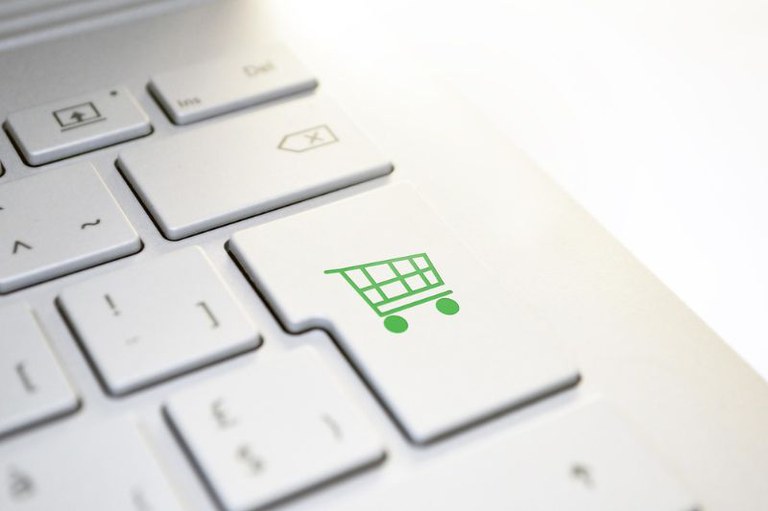 foto em detalhe de um teclado de computador com destaque para uma das teclas com a figura de um carrinho de compras verde