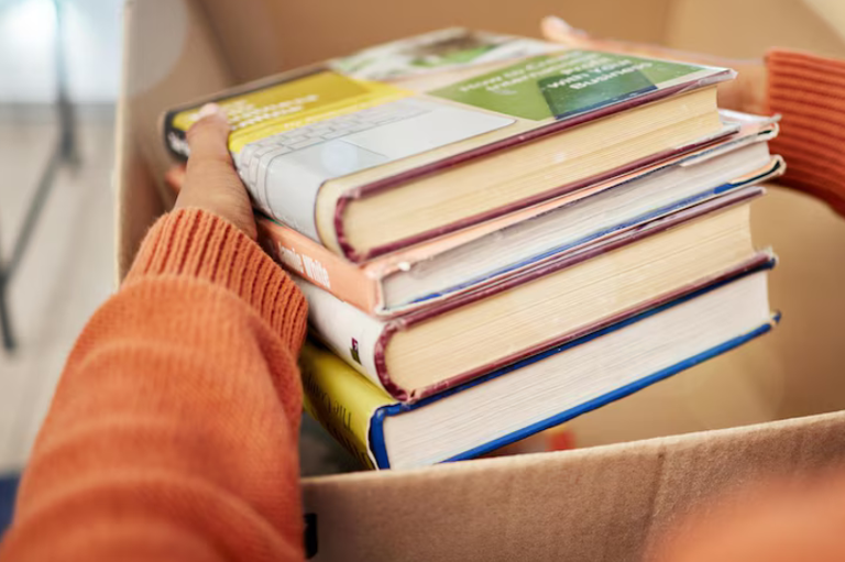 A imagem minimalista em tons de marrom-acinzentado mostra duas setas curvas em ciclo (troca) acima do texto "DESFAZIMENTO DE BENS"