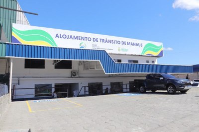 Foto mostra a fachada do alojamento de trânsito de Manaus com um carro estacionado na frente
