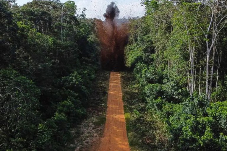Foto mostra um trecho de uma pista de pouso de terra no meio da floresta