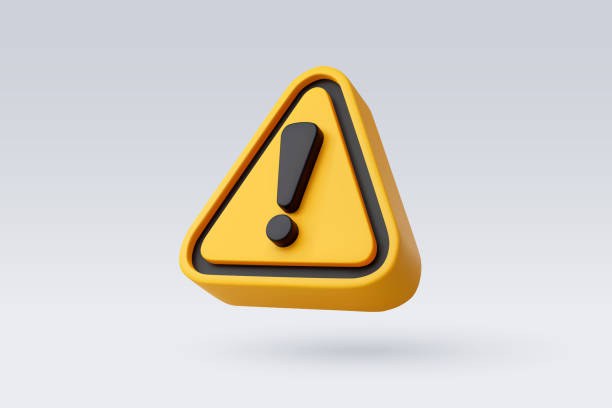Ícone de alerta em formato triangular, na cor amarela com bordas pretas e arredondadas, contendo um ponto de exclamação preto no centro. O símbolo aparece flutuando sobre um fundo cinza-claro liso, em estilo tridimensional.