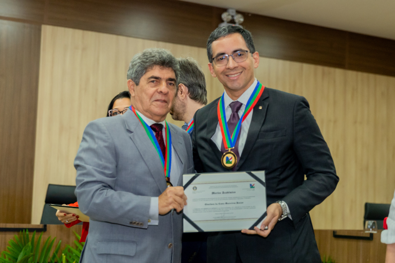 Dois homens, um deles segurando uma premiação