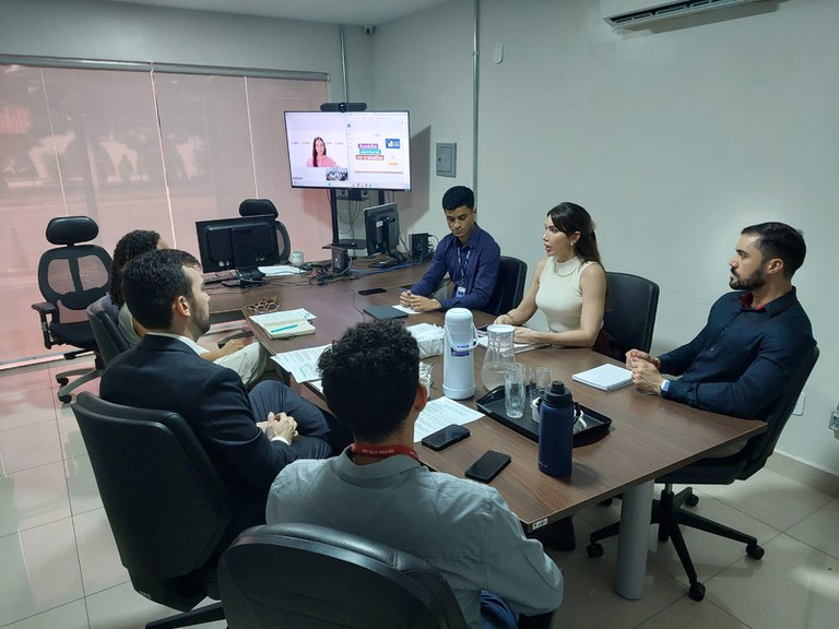 Foto mostra participantes da reunião em volta de uma mesa