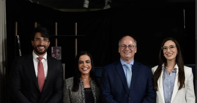 4 pessoas estão em pé sorrindo para a foto. Dois homens e duas mulheres. Uma delas é a procuradora Ludmilla Vieira.