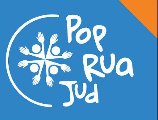 Logomarca do programa PopRuaJud, sobre um fundo azul com um pequeno triângulo laranja no canto superior direito. À esquerda, há um desenho circular formado por quatro figuras humanas representadas por círculos (as cabeças) e mãos estendidas, formando um símbolo de união e acolhimento. À direita da imagem, está o nome “PopRuaJud” escrito em letras brancas com tipografia informal