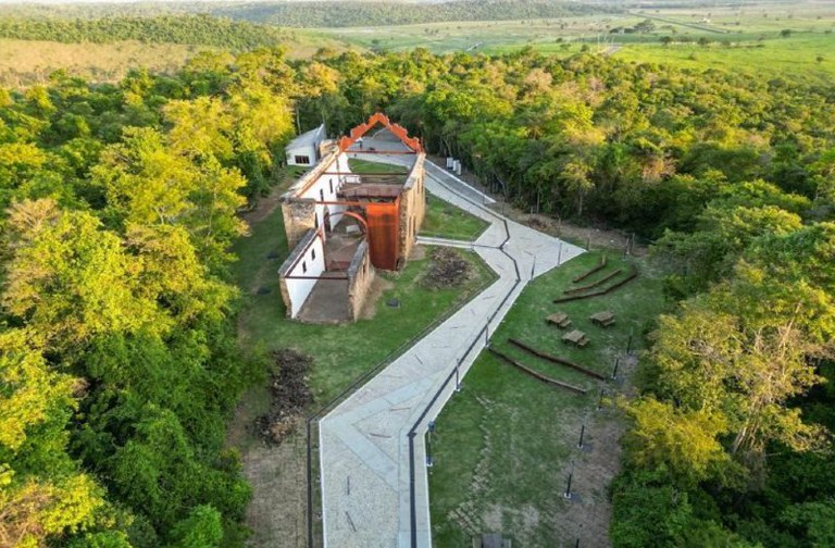 Foto aérea mostra igreja antiga sem teto e com paredes descascadas. O local parece estar em obras