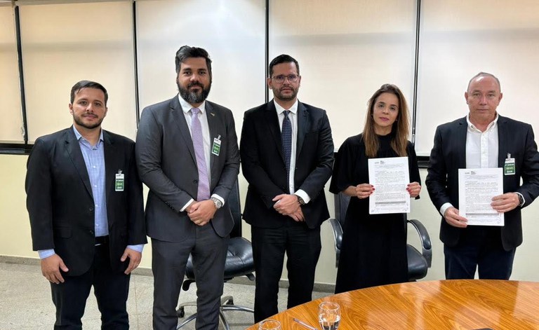 Foto na horizontal de 5 pessoas em pé. Da direita para a esquerda está: o presidente da Agrodefesa, José Ricardo Caixeta; a procuradora-chefe do MPF em Goiás, Léa Batista de Oliveira Moreira Lima; o procurador da República, Raul Batista Leite; além de duas testemunhas. Os dois primeiros (da direita para a esquerda) estão segurando o documento assinado.
