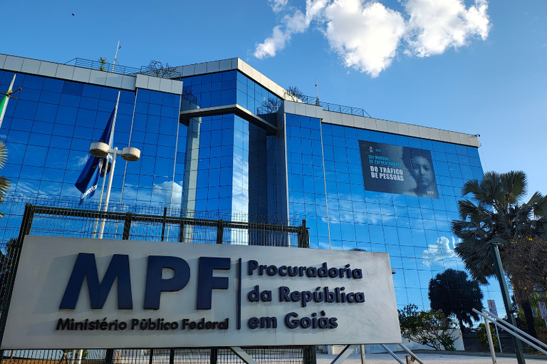 Fachada do MPF em Goiás. O prédio de janelas azuis destaca um adesivo grande preto da campanha