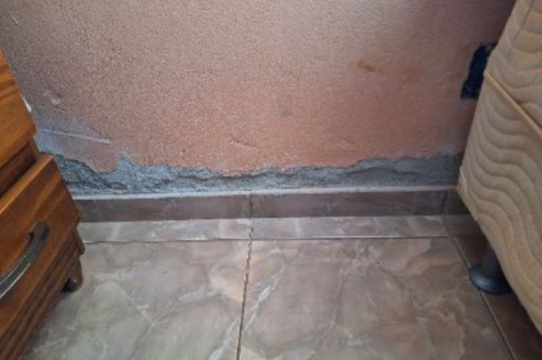 Foto mostra infiltração na parede da casa do condomínio