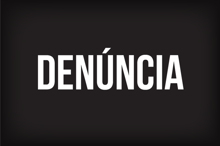 Arte mostra um fundo preto com a palavra "Denúncia" escrita em grandes letras brancas.