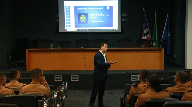 Procurador-chefe do MPF apresenta atuação da instituição a estudantes do CFO da Uema Procurador-chefe do MPF no Maranhão realiza palestra em auditório para alunos do Curso de Formação de Oficiais da Uema. Ao fundo, projeção apresenta informações sobre a Procuradoria da República no Maranhão.