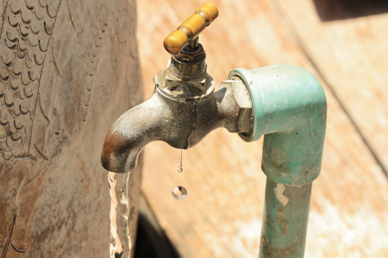 Foto mostra uma torneira antiga jorrando água