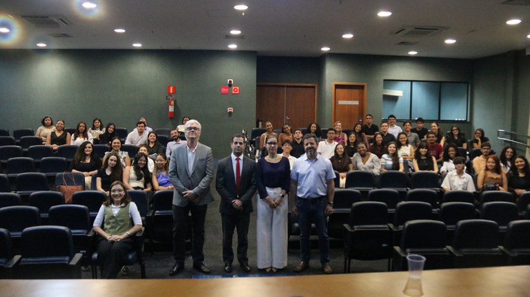 fotografia de palestra feita pelo Dr. Alexandre Soares através do Projeto Conhecendo o MPF. O Procurador está ao centro da imagem, em pé, acompanhado de professores da Uema e, logo atrás, estudantes de direito da Uema.
