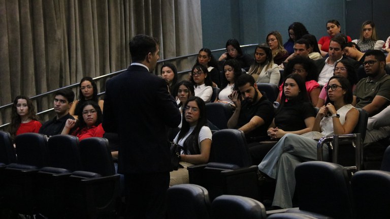 A imagem apresenta o Dr. Alexandre Soares, de costas, falando com uma turma de Direito da Undb no Auditório da Procuradoria da República no Maranhão.