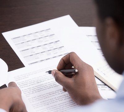 Menino segurando caneta com a mão.