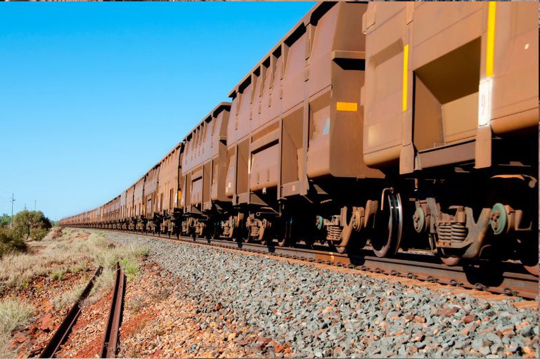 Foto mostra em detalhe um trem de carga no trilho